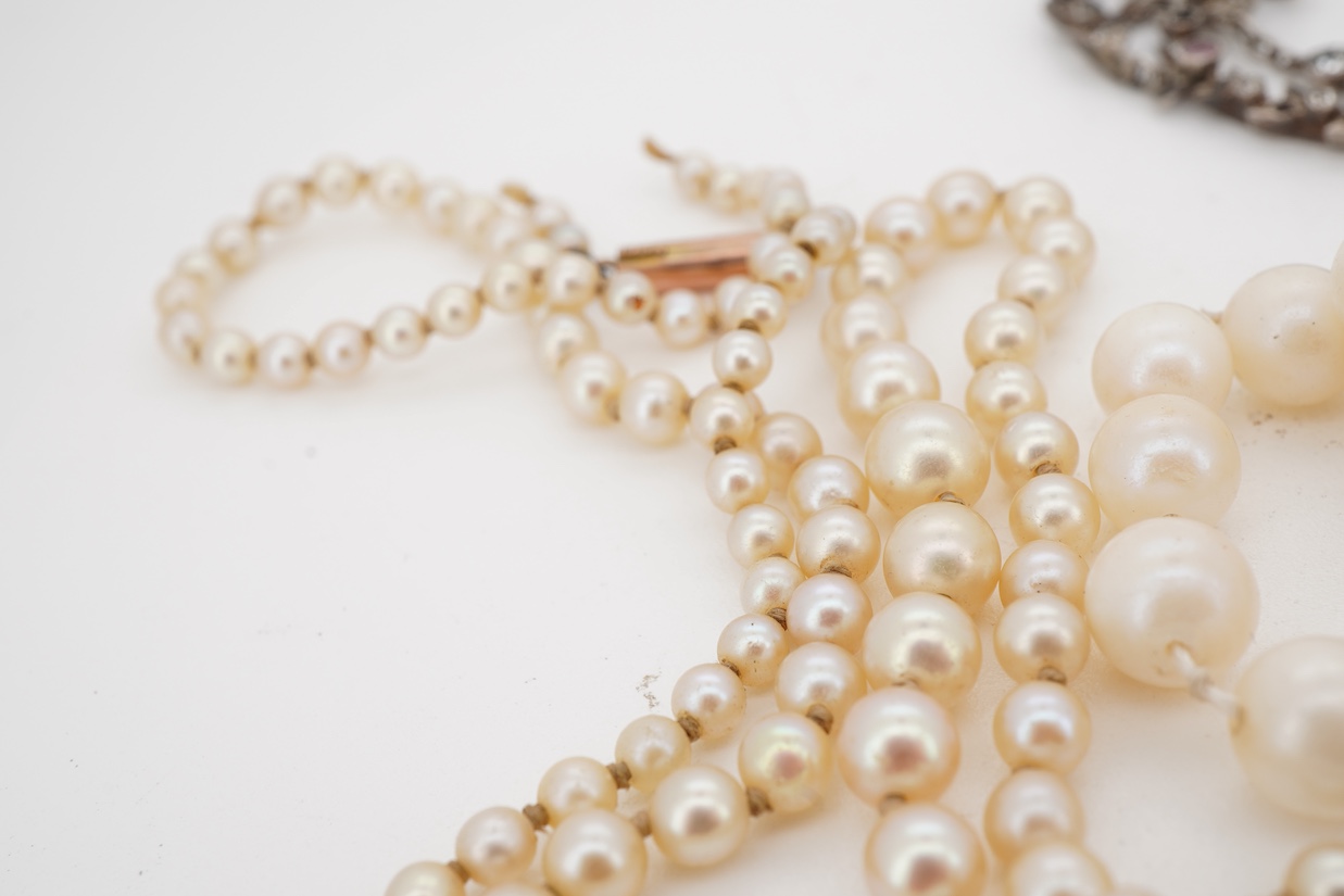 An early 20th century French white metal and three colour paste set drop pendant necklace, 46cm, together with two cultured pearl necklaces, both with 9ct clasps, both approx. 44cm, one a.f.